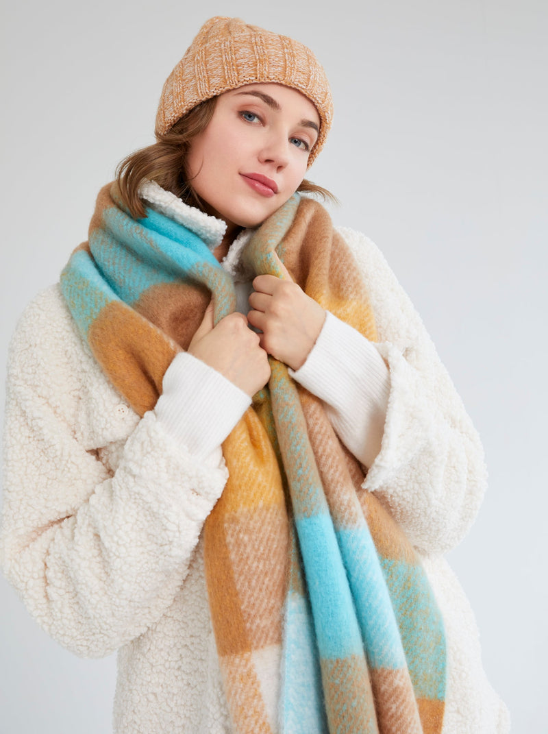 A front view of woman wearing The Shiraleah Stella Hat is a winter hat that features a cozy knit texture and a solid tan color.