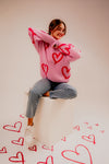 Model showing Long Sleeve Round Neck Heart Printed Sweater with hearts all around her