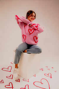 Model showing Long Sleeve Round Neck Heart Printed Sweater with hearts all around her