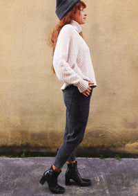 left side view of woman on sidewalk wearing SWEATER TURTLENECK - KNIT PEARL beige