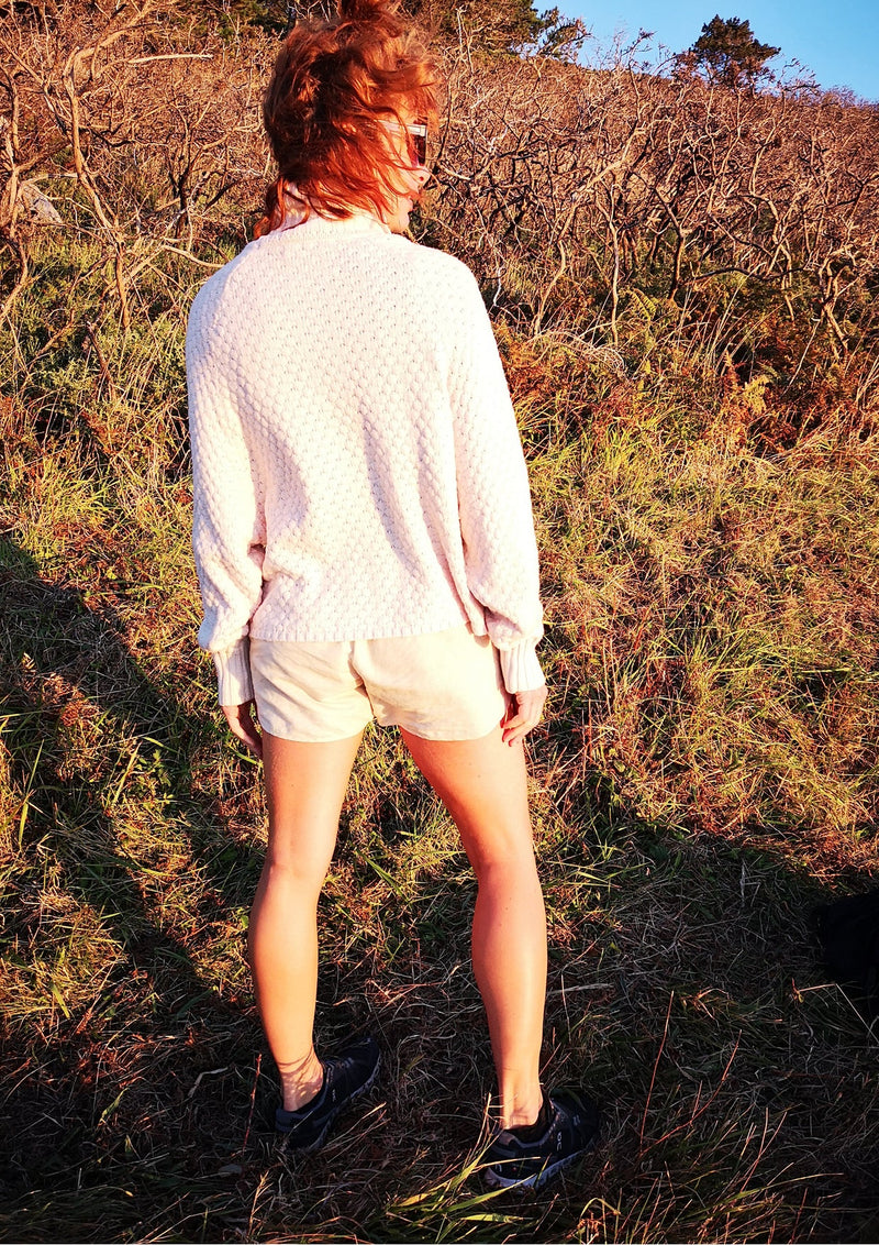 back view of woman outside wearing SWEATER TURTLENECK - KNIT PEARL beige