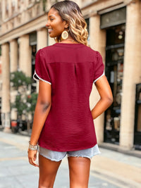 Model showing back of burgundy blouse