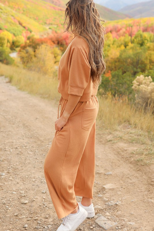 Model on dirt road showing left side of Journey Pant- color is saddle